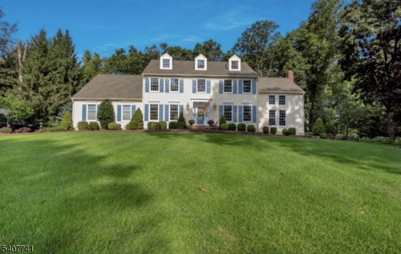 a view of a house with a big yard and large trees