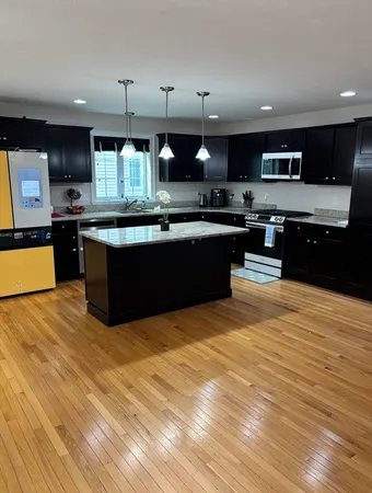 a large kitchen with stainless steel appliances and a large kitchen island