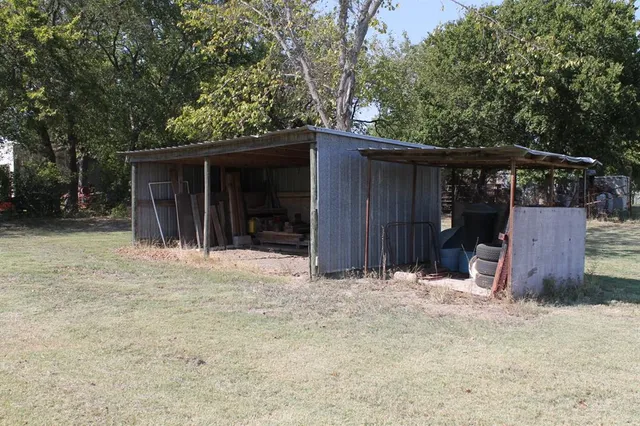 a wooden house with trees in the background