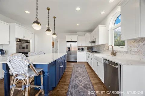 a large kitchen with kitchen island a large island in the center and stainless steel appliances