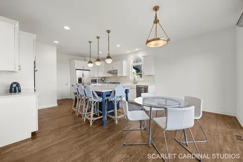 a view of a dining room with furniture wooden floor and a chandelier