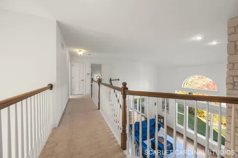 a view of a hallway with wooden floor and stairs