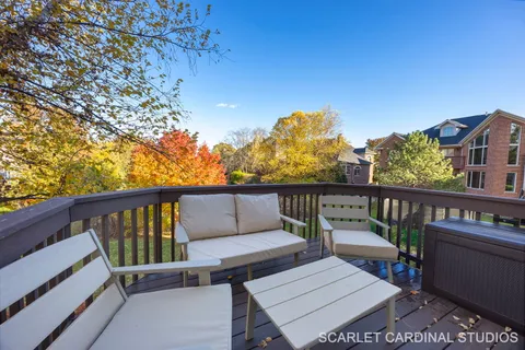 a view of a balcony with wooden floor and outdoor seating