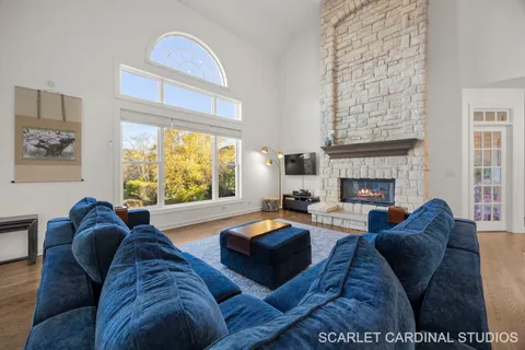 a living room with fireplace furniture and a large window