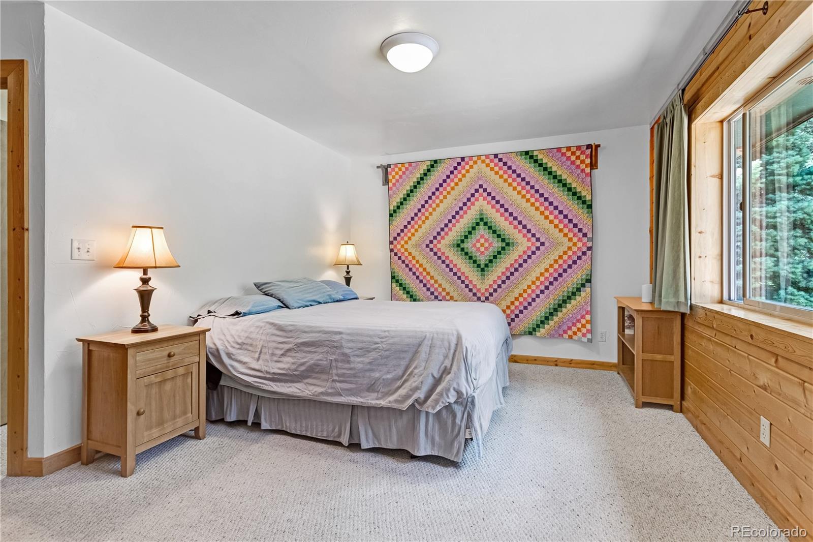 83 Forest Lane Howard, CO 81233 - Photo 13 of 43 a bedroom with a bed and a lamp next to a window