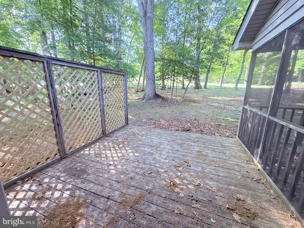 a view of backyard with green space and wooden fence