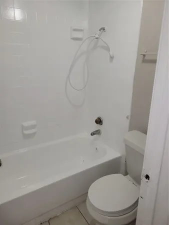 a white toilet and tub sitting next to a bathroom sink