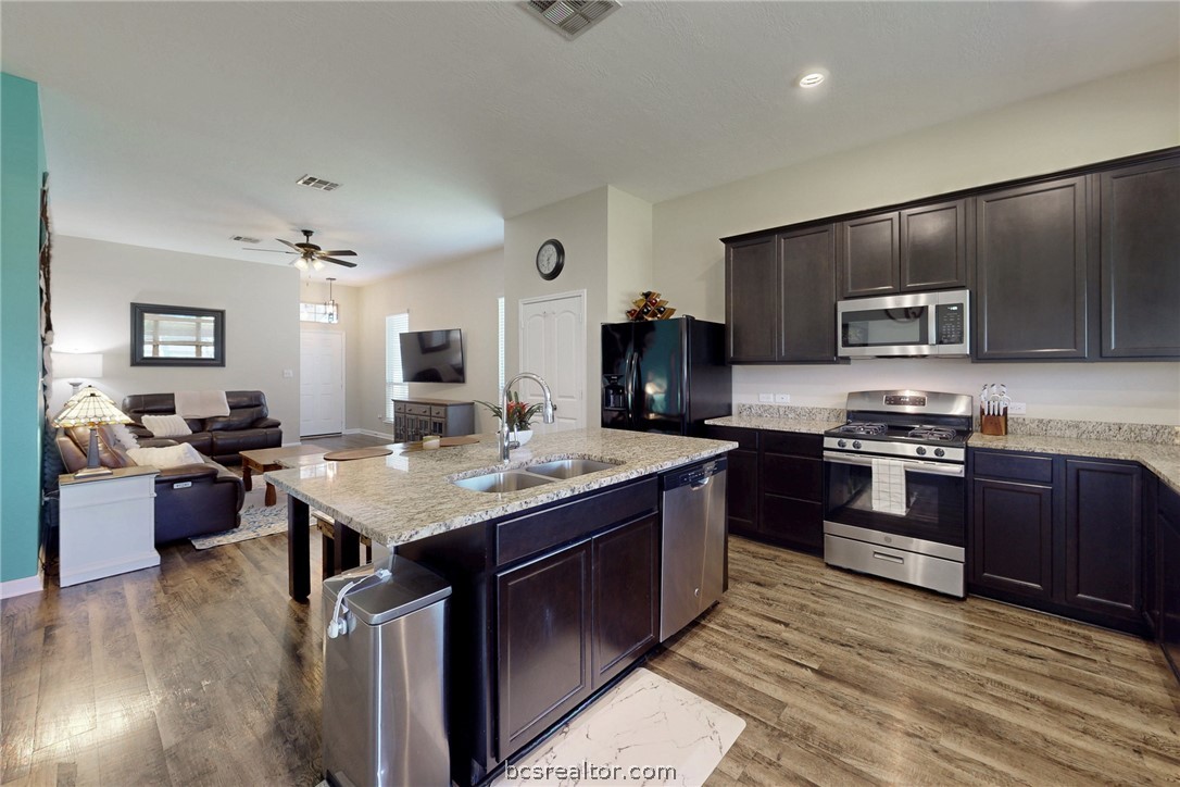 2071 Positano Loop Bryan, TX 77808 - Photo 10 of 31 a large kitchen with stainless steel appliances granite countertop a stove refrigerator and a view of living room