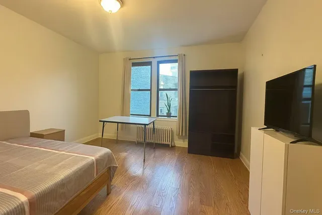 a bedroom with a bed and a flat screen tv