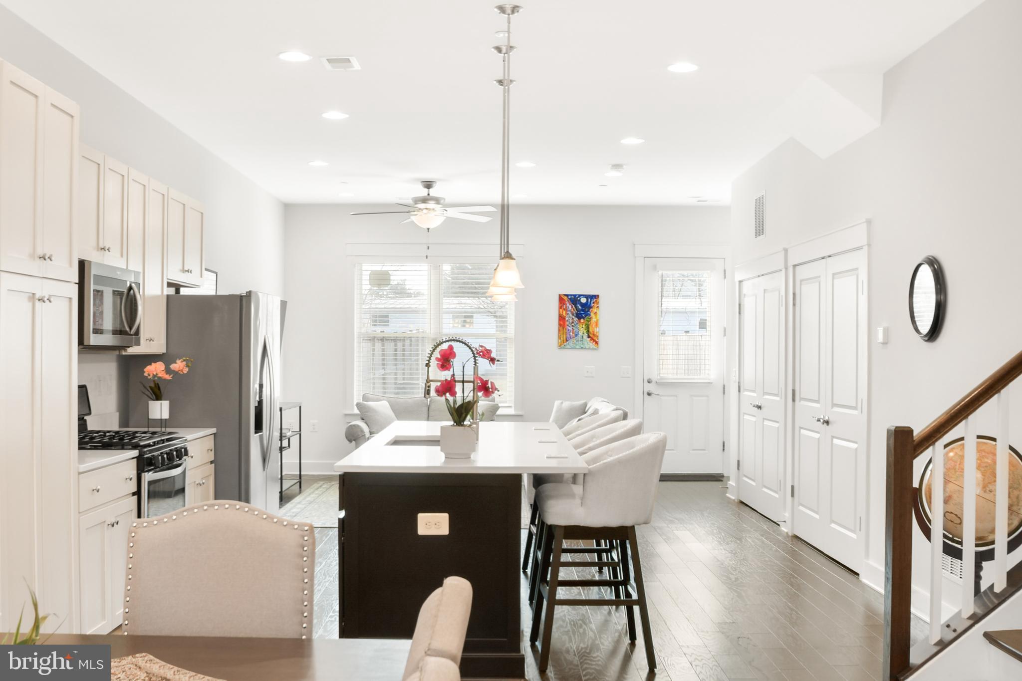 224 East 6th Street Frederick, MD 21701 - Photo 13 of 55 a view of a dining room and livingroom with furniture wooden floor a rug a flat screen tv a painting and a chandelier