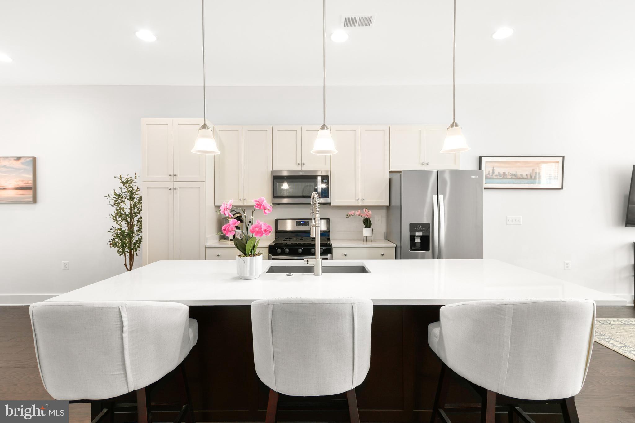 224 East 6th Street Frederick, MD 21701 - Photo 16 of 55 a kitchen with kitchen island a dining table chairs and a refrigerator