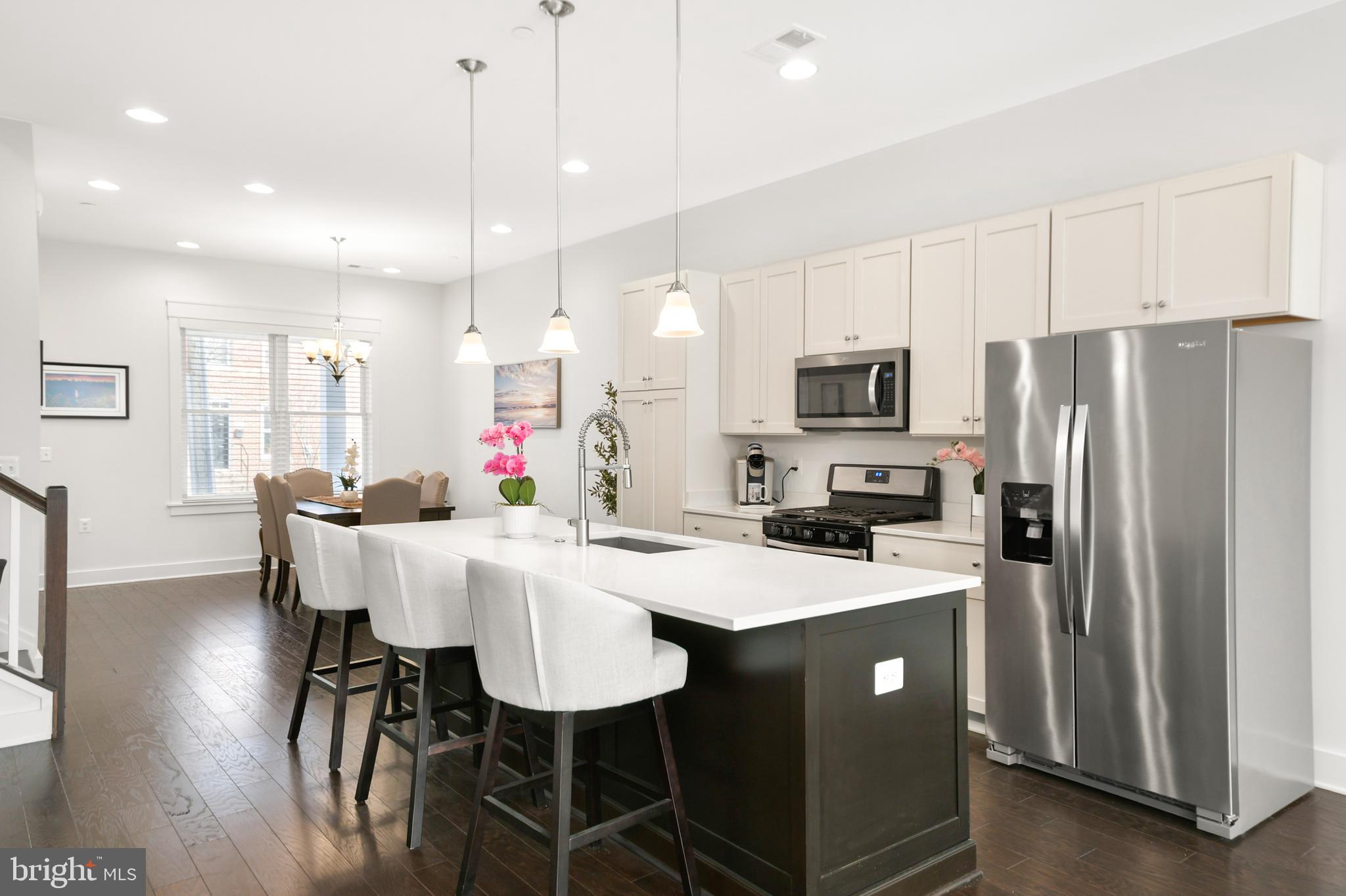 224 East 6th Street Frederick, MD 21701 - Photo 17 of 55 a kitchen with stainless steel appliances granite countertop a dining table chairs refrigerator and microwave
