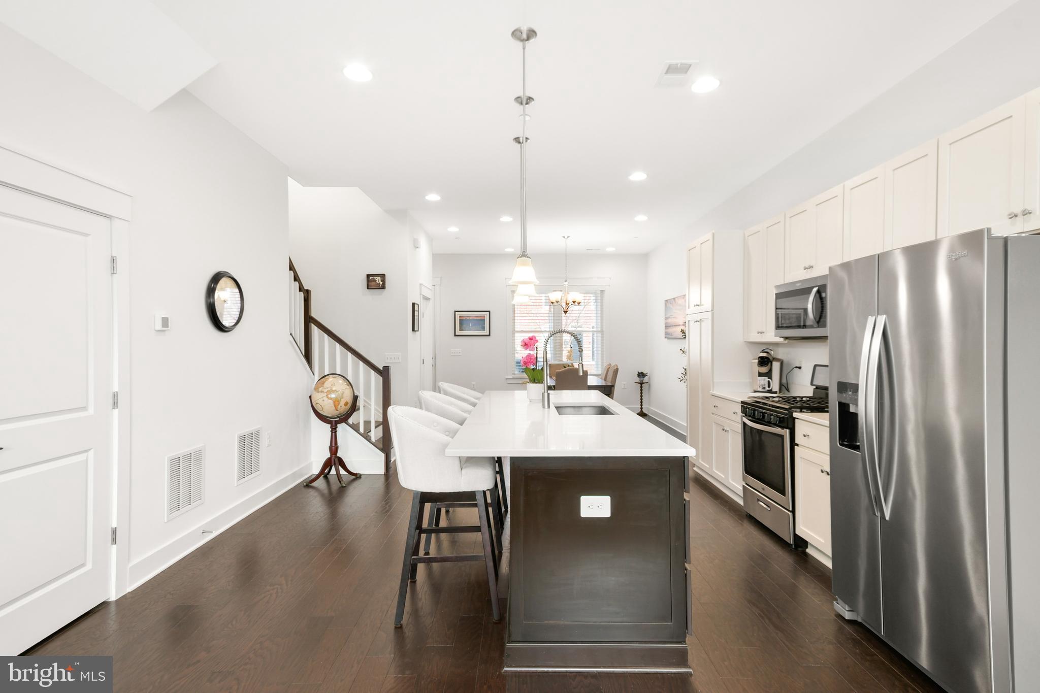 224 East 6th Street Frederick, MD 21701 - Photo 18 of 55 a kitchen with stainless steel appliances kitchen island a table chairs in it and wooden floors