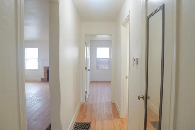a view of a hallway with wooden floor