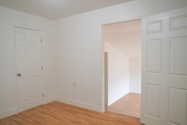 a view of an empty room with wooden floor