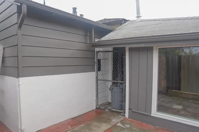 a view of a backyard with potted plants and wooden fence