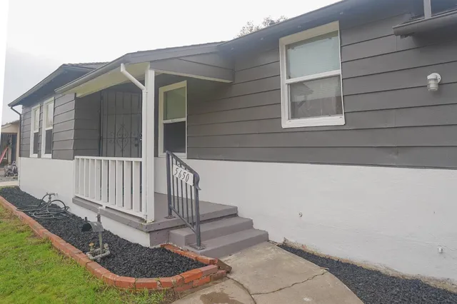 a view of wooden house with a small yard