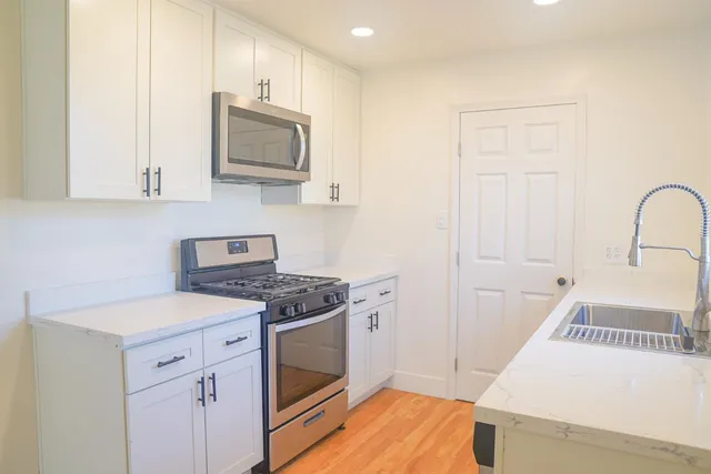 a kitchen with a stove microwave and sink