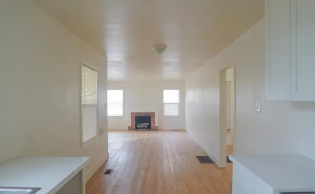 a view of a hallway with wooden floor and a fireplace