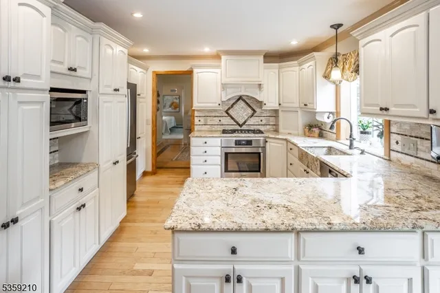 a kitchen with granite countertop a stove a sink and dishwasher wooden cabinets with granite countertops