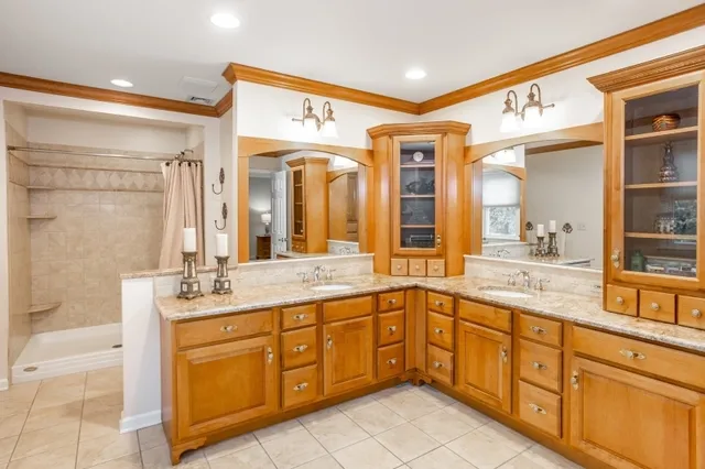 a spacious bathroom with a tub sink and mirror