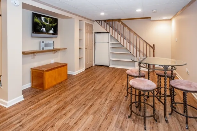 a room with pool table and wooden floor