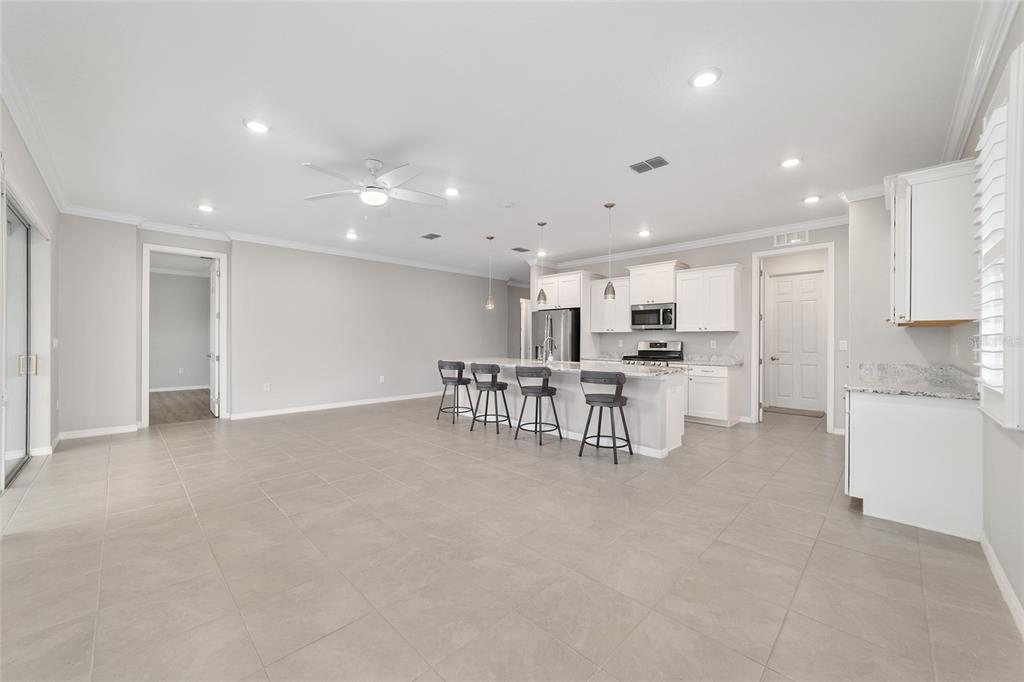 10064 Southwest 88th Street Ocala, FL 34481 - Photo 13 of 47 a kitchen with stainless steel appliances kitchen island lots of white cabinets a dining table and chairs