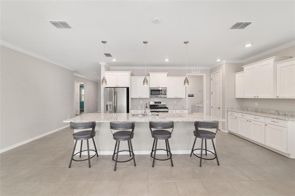 10064 Southwest 88th Street Ocala, FL 34481 - Photo 15 of 47 a white kitchen with a sink table and chairs