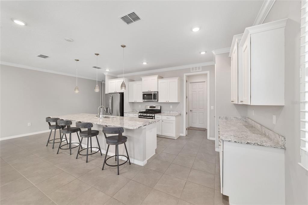 10064 Southwest 88th Street Ocala, FL 34481 - Photo 16 of 47 a kitchen with a dining table chairs and white stainless steel appliances