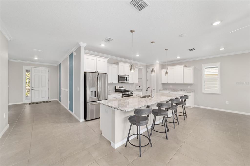 10064 Southwest 88th Street Ocala, FL 34481 - Photo 17 of 47 a kitchen with refrigerator and chairs