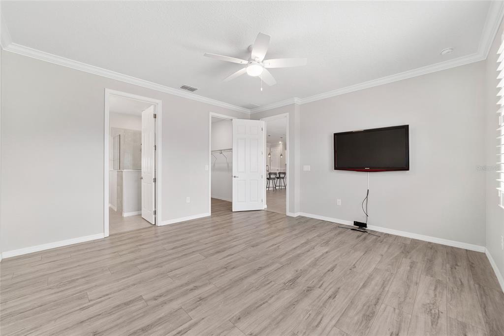10064 Southwest 88th Street Ocala, FL 34481 - Photo 22 of 47 a view of an empty room with wooden floor and a flat screen tv