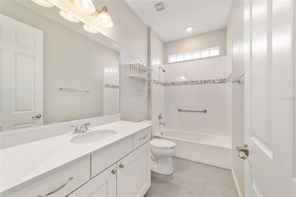 10064 Southwest 88th Street Ocala, FL 34481 - Photo 31 of 47 a bathroom with a toilet a sink and a large mirror