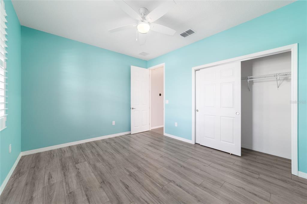 10064 Southwest 88th Street Ocala, FL 34481 - Photo 33 of 47 an empty room with wooden floor and a ceiling fan