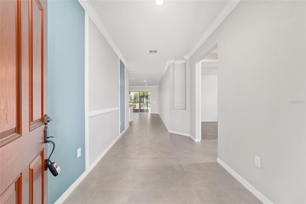10064 Southwest 88th Street Ocala, FL 34481 - Photo 9 of 47 a view of a hallway with wooden floor and entryway