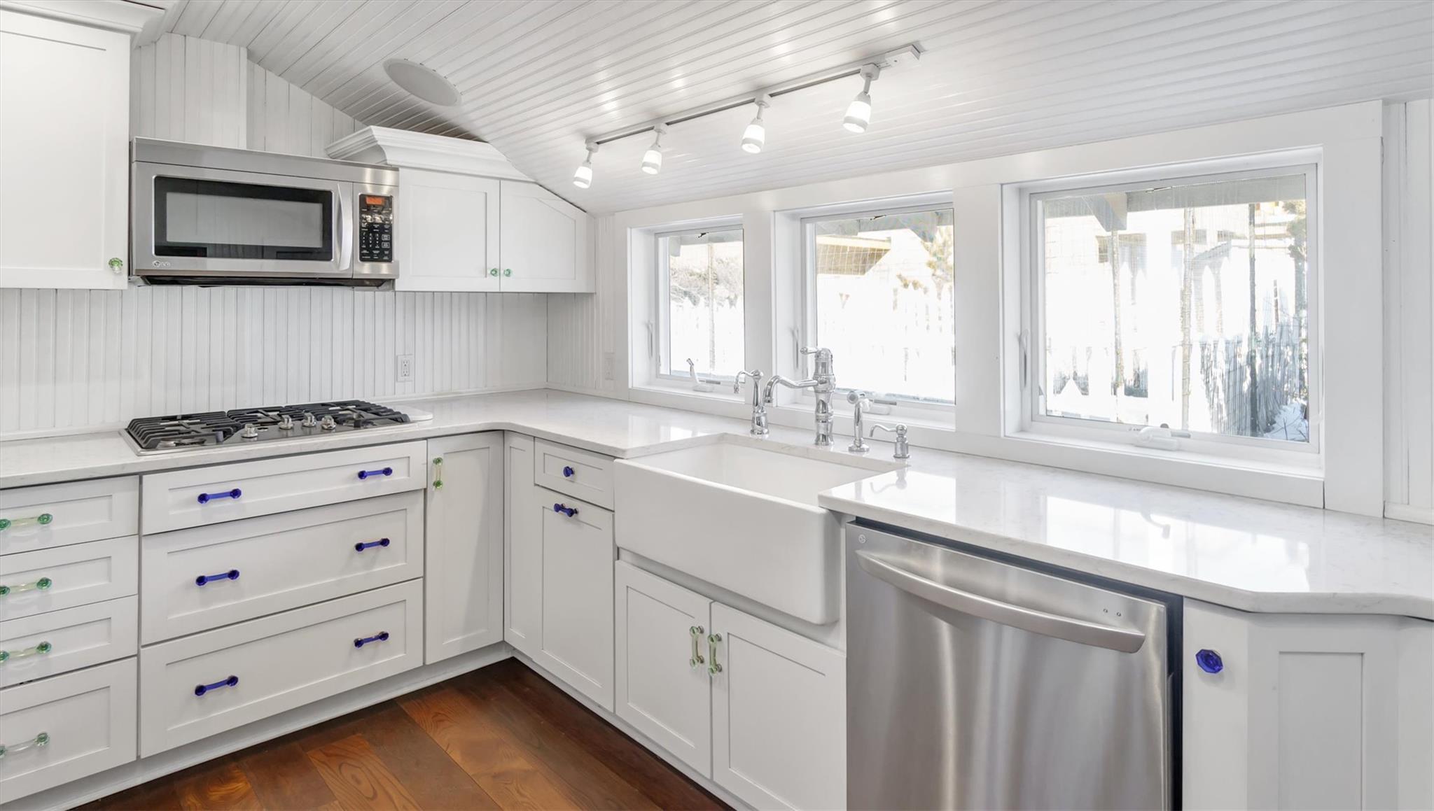 234 Dune Road Quogue, NY 11959 - Photo 11 of 34 a kitchen with cabinets appliances a sink and a window