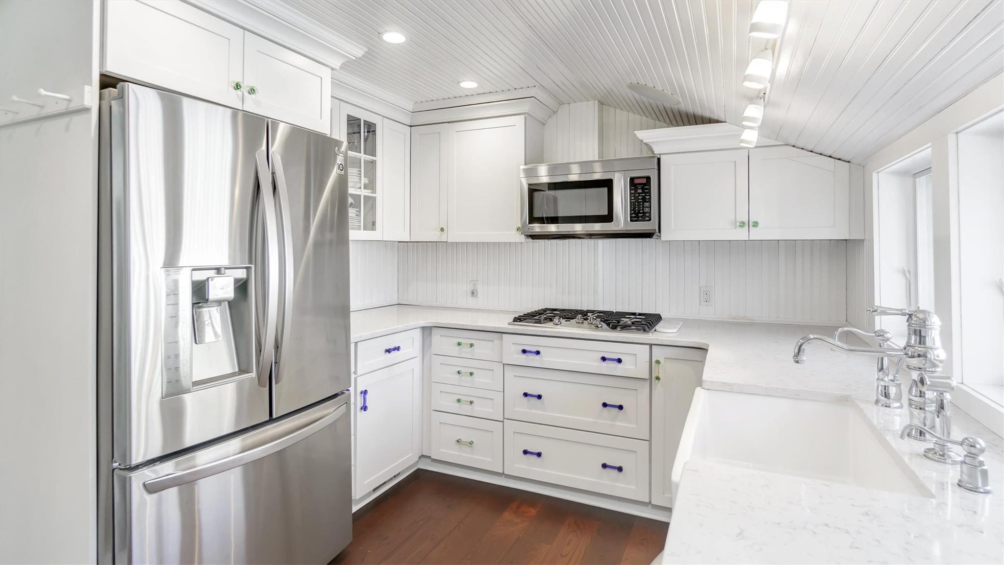234 Dune Road Quogue, NY 11959 - Photo 12 of 34 a kitchen with stainless steel appliances a refrigerator stove and microwave