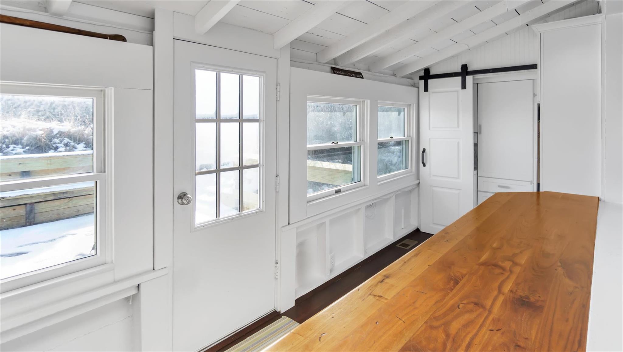 234 Dune Road Quogue, NY 11959 - Photo 16 of 34 a view of a bedroom with wooden floor and windows