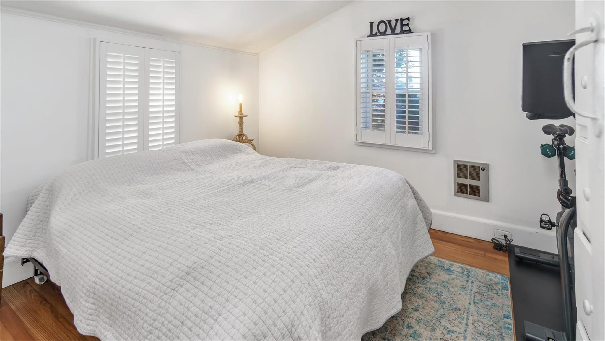 234 Dune Road Quogue, NY 11959 - Photo 18 of 34 a spacious bedroom with a bed and a flat screen tv