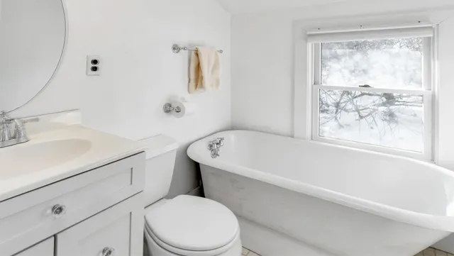a white toilet sitting next to a bath tub