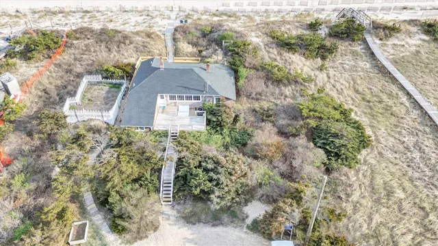 a view of a house with a small yard and large trees