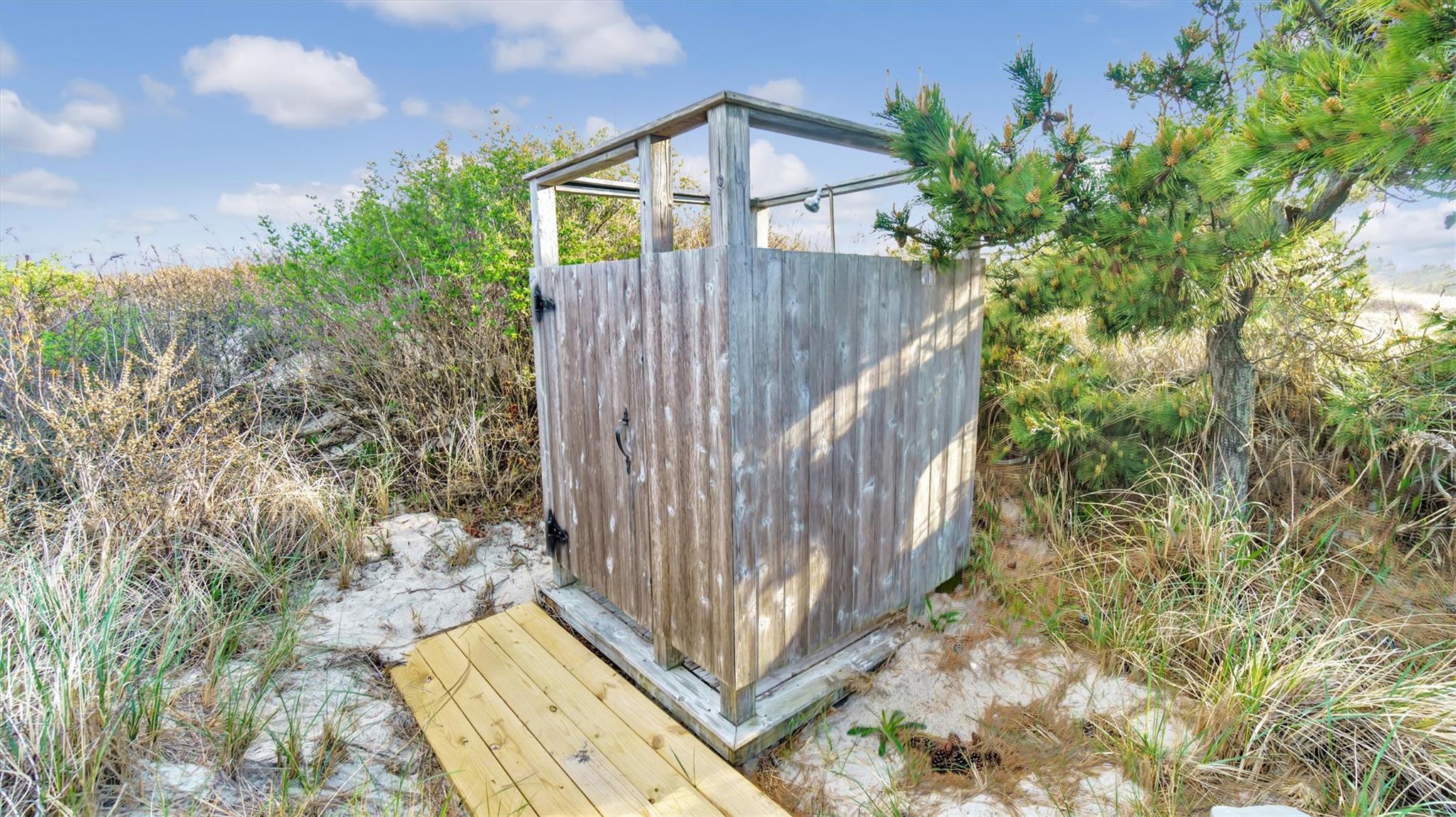 234 Dune Road Quogue, NY 11959 - Photo 28 of 34 a view of a house with a small yard and large trees