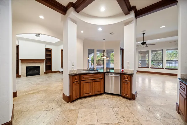 a large kitchen with stainless steel appliances granite countertop a stove and a view of living room