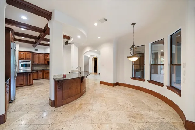 a view of an empty room and kitchen with furniture