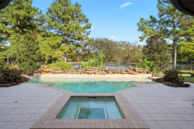 a view of yard with swimming pool and green space