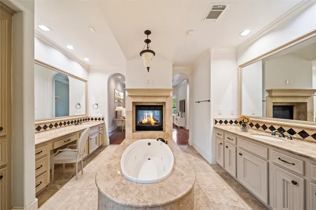 a large white kitchen with a stove and a fireplace