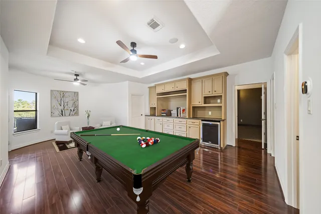 a room with pool table and wooden floor