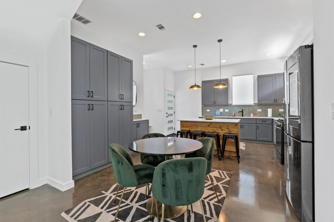 2411 East 11th Street, Unit 1 Austin, TX 78702 - Photo 2 of 17 a kitchen with granite countertop kitchen island stainless steel appliances a sink and a refrigerator