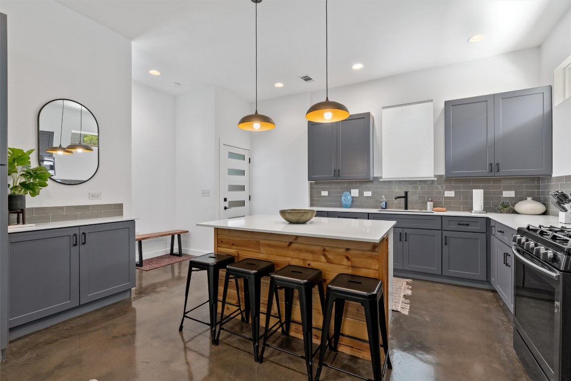 2411 East 11th Street, Unit 1 Austin, TX 78702 - Photo 3 of 17 a kitchen with a table chairs sink and cabinets