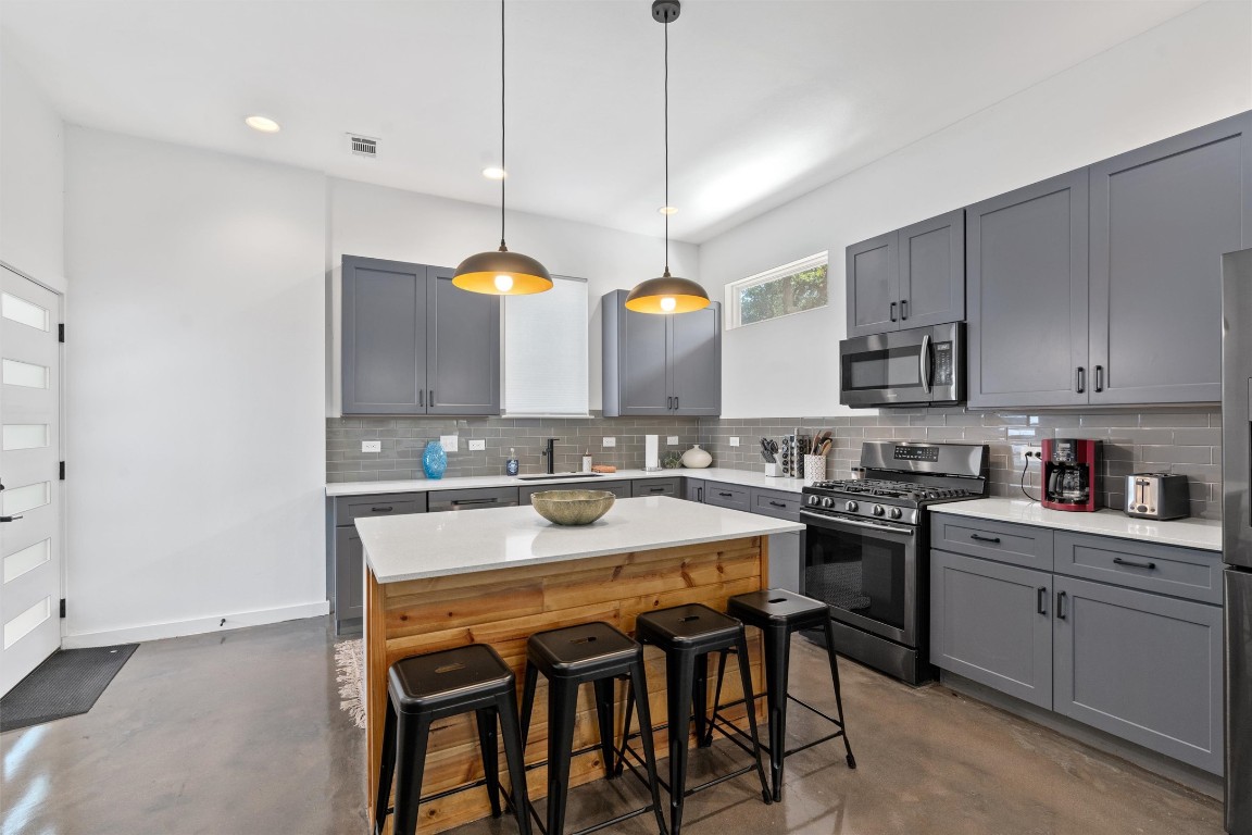 2411 East 11th Street, Unit 1 Austin, TX 78702 - Photo 7 of 17 a kitchen with a stove a sink and chairs