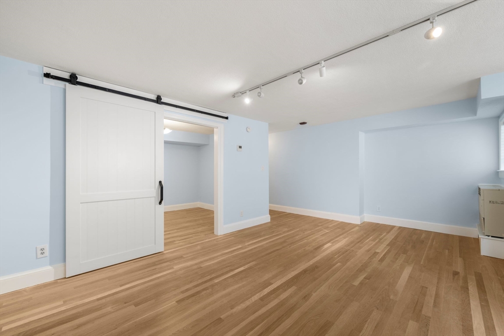 242 Beacon Street, Unit 1 Boston, MA 02116 - Photo 12 of 29 a view of an empty room with wooden floor and a window